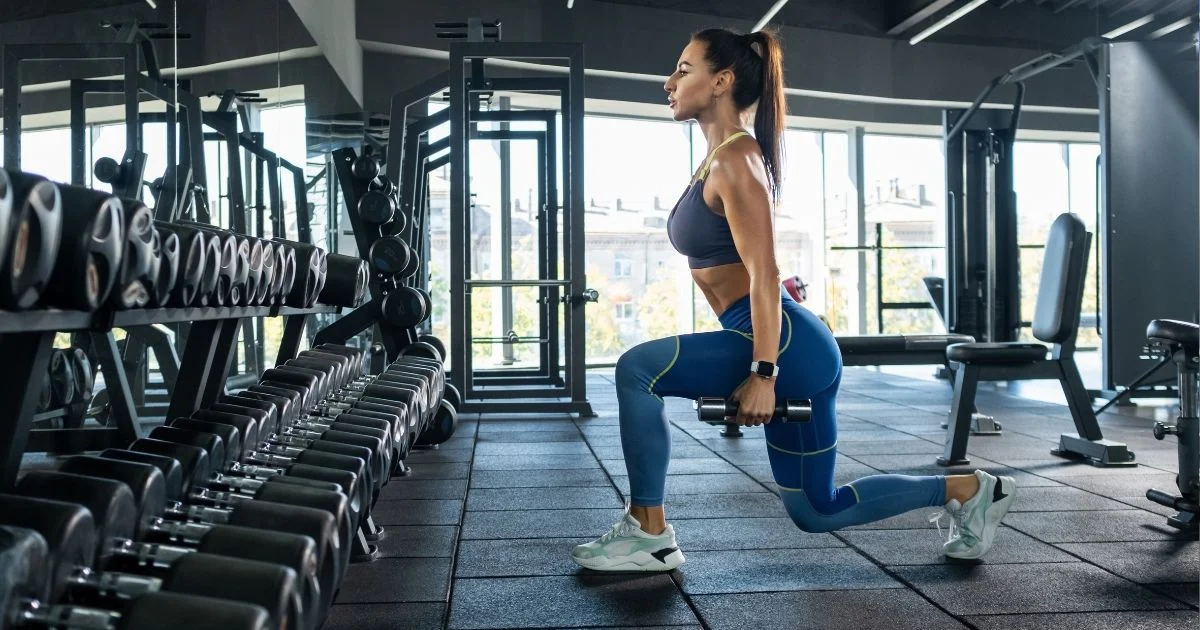 fit_woman_doing_a_dumbbell_lunge_in_the_gym